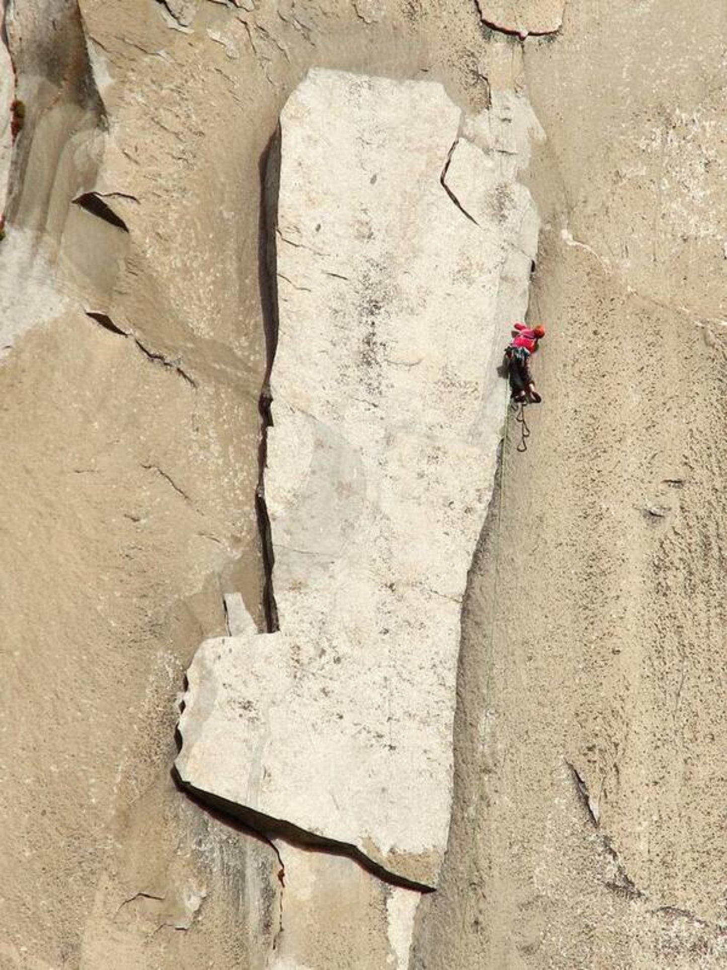 A photo print featuring a person on a boat in a narrow passage in a large rock wall, set against a beige and white tone scale.
