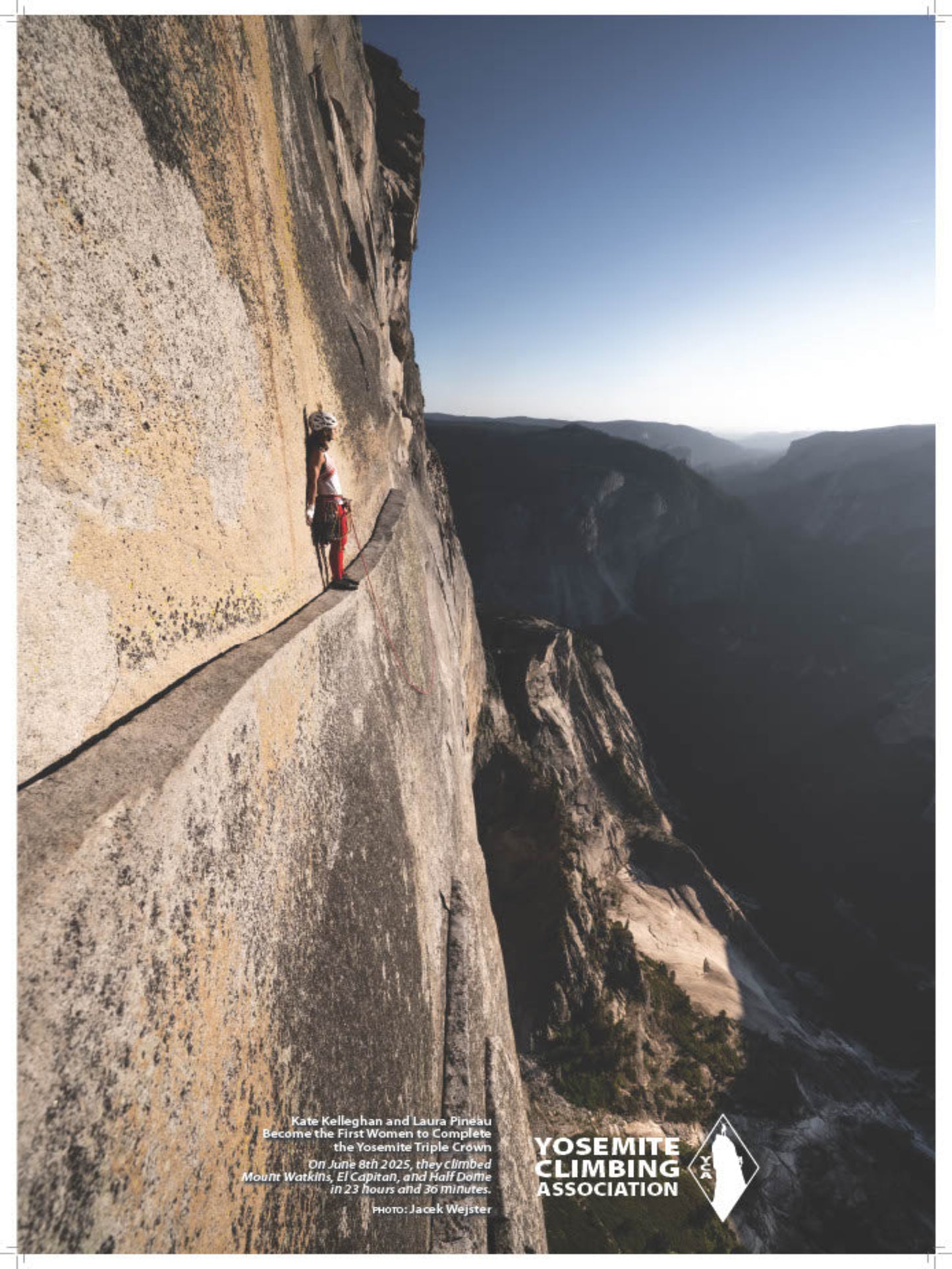 Person climbing a steep cliff face with a scenic view of a valley.